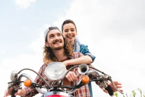 low angle view of beautiful girl sitting behind and hugging young man